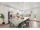 Modern kitchen with white cabinets, granite countertops, a large island with seating, and stainless steel appliances at 2054 S Upham Way, Denver, CO 80227