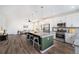 Modern kitchen featuring stainless steel appliances, a granite-topped island, and an open layout to the living room at 2054 S Upham Way, Denver, CO 80227