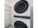 Laundry area featuring a stacked washer/dryer and shelving providing space for organization and convenience at 2054 S Upham Way, Denver, CO 80227