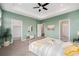 Large primary bedroom showcasing a tray ceiling, walk-in closet, en-suite bathroom, and modern design at 2054 S Upham Way, Denver, CO 80227