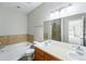 Bright bathroom featuring double sinks, tub with tile surround, and a separate shower at 9434 Ashbury Cir # 203, Parker, CO 80134
