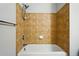 A neutral tile backsplash surrounds a bath tub with shower head at 9434 Ashbury Cir # 203, Parker, CO 80134