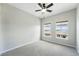 Neutral bedroom features a ceiling fan, two windows with view of the neighbor's unit at 9434 Ashbury Cir # 203, Parker, CO 80134