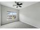 A bright bedroom with soft, gray walls, large window, neutral trim, and a ceiling fan at 9434 Ashbury Cir # 203, Parker, CO 80134