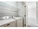 A laundry room with a white washer, dryer, and storage shelf at 9434 Ashbury Cir # 203, Parker, CO 80134