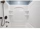 Renovated shower and tub with molded shelving and modern fixtures, showcasing a clean, minimalist design at 1346 S Grant St, Longmont, CO 80501