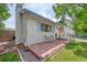 Charming home exterior with painted brick, colorful door, manicured lawn, and quaint outdoor seating at 1346 S Grant St, Longmont, CO 80501