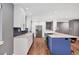 Bright kitchen features white cabinets, quartz countertops, stainless appliances, island with bar seating at 1346 S Grant St, Longmont, CO 80501