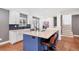 Bright kitchen features white cabinets, quartz countertops, stainless appliances, island with bar seating at 1346 S Grant St, Longmont, CO 80501