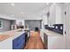Modern kitchen featuring white cabinets, blue backsplash, and a large island with cooktop at 1346 S Grant St, Longmont, CO 80501