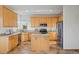 Traditional kitchen with stainless steel appliances, center island, and light wood cabinetry at 4704 Cedar Glen Pl, Castle Rock, CO 80109