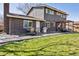 Outdoor entertaining space on a concrete patio in backyard with dark brick home, grill, dining set, and pergola at 9290 N Raleigh St, Westminster, CO 80031