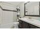 Clean bathroom featuring tiled shower-tub combination, modern vanity with sink, and a decorative mirror at 9290 N Raleigh St, Westminster, CO 80031
