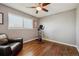 Bedroom with hardwood floors, a ceiling fan, large window, exercise bike and stylish leather chair at 9290 N Raleigh St, Westminster, CO 80031