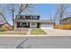 Charming two-story home with a brick and grey facade, mature tree, and well-maintained front yard at 9290 N Raleigh St, Westminster, CO 80031