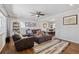 Inviting living room with hardwood floors, ceiling fan, a comfortable leather sofa, and an open view to the dining area at 9290 N Raleigh St, Westminster, CO 80031