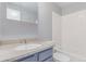 Bathroom features a blue vanity with white sink and a white tiled shower-tub at 9328 Fenton Ct, Westminster, CO 80031