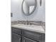Bathroom featuring stylish vanity with a modern faucet, stone backsplash, and oval mirror at 9328 Fenton Ct, Westminster, CO 80031