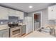 Functional kitchen featuring white cabinets, stainless steel appliances, and access to the laundry area at 9328 Fenton Ct, Westminster, CO 80031
