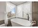 Bright bathroom boasts a soaking tub, large window with soft curtains, and modern finishes at 9145 Sugarstone Cir, Highlands Ranch, CO 80130