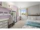 Cozy bedroom features a desk and shelves, a comfortable bed, and a view from the window at 9145 Sugarstone Cir, Highlands Ranch, CO 80130