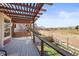 Relaxing deck featuring a wooden pergola, glass railings, and scenic views of the surrounding landscape at 9145 Sugarstone Cir, Highlands Ranch, CO 80130