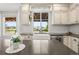 Bright kitchen featuring a large island, white cabinetry, and a farmhouse sink at 9145 Sugarstone Cir, Highlands Ranch, CO 80130