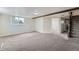 Spacious basement with neutral carpet, a bright window, and access to a stairway at 13805 W 82Nd Ave, Arvada, CO 80005