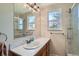Bathroom featuring a marble vanity countertop, large mirror, and glass shower door at 13805 W 82Nd Ave, Arvada, CO 80005