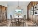 Charming dining room with wood paneled accent wall and a light filled window with backyard view at 13805 W 82Nd Ave, Arvada, CO 80005