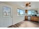A well lit dining room with wood floors, a ceiling fan and multiple windows at 13805 W 82Nd Ave, Arvada, CO 80005