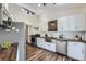 Bright kitchen with stainless steel appliances, white cabinetry, and a stylish backsplash at 13805 W 82Nd Ave, Arvada, CO 80005