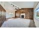 Large living room featuring a fireplace, wood-paneled accent wall, and ample natural light at 13805 W 82Nd Ave, Arvada, CO 80005