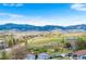 Scenic view of a quiet neighborhood with rolling hills and mountain views at 13805 W 82Nd Ave, Arvada, CO 80005