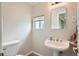 Powder room features a pedestal sink, toilet, and small window at 13805 W 82Nd Ave, Arvada, CO 80005