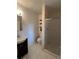 A full bathroom with a vanity sink, tile floors, and a standing shower with glass doors at 1477 S Wright Ct, Lakewood, CO 80228