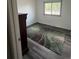 A simple bedroom with a window that gives a view to the trees outside and a multi-colored carpet at 1477 S Wright Ct, Lakewood, CO 80228
