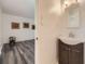 Bathroom featuring a single sink vanity and a view into a hardwood floored bedroom at 1477 S Wright St, Lakewood, CO 80228