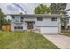 Charming home with light gray siding, brick accents, well-kept lawn, and a convenient two-car garage at 1477 S Wright St, Lakewood, CO 80228
