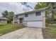Inviting home featuring a two-car garage, light gray siding, and well-manicured lawn at 1477 S Wright St, Lakewood, CO 80228