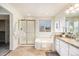 Well-lit bathroom with separate tub and shower, complemented by neutral tile and granite countertops at 6876 Edgewood Way, Highlands Ranch, CO 80130