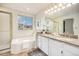 Bright bathroom featuring a separate tub and shower, granite countertops, and updated fixtures at 6876 Edgewood Way, Highlands Ranch, CO 80130