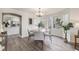 Dining area with modern chandelier, neutral tones, and an arched entry into a bright and airy kitchen at 6876 Edgewood Way, Highlands Ranch, CO 80130