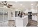 Well-lit kitchen featuring a central island, modern appliances, and sliding glass doors leading to outdoor deck at 6876 Edgewood Way, Highlands Ranch, CO 80130