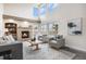 Bright living room with a cozy brick fireplace, high ceilings, and ample natural light at 6876 Edgewood Way, Highlands Ranch, CO 80130