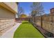 A low-maintenance backyard featuring artificial turf, a walkway, and a wooden fence, perfect for outdoor enjoyment at 4560 Flanders Way, Denver, CO 80249