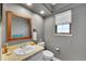 Well-lit bathroom with a wooden framed mirror and gray walls at 4560 Flanders Way, Denver, CO 80249