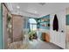 Bright bathroom featuring a walk-in shower, unique window, and ample storage shelving at 4560 Flanders Way, Denver, CO 80249