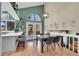 Open dining area with a marble table, pendant lighting, and views of the modern kitchen at 4560 Flanders Way, Denver, CO 80249