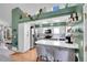 Modern kitchen with white cabinets, gray island, stainless steel appliances, and hardwood floors at 4560 Flanders Way, Denver, CO 80249